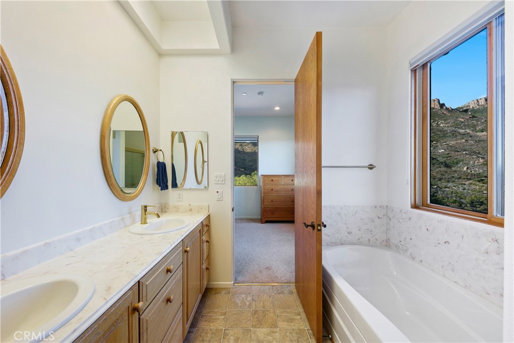 8400 Mipolomol Road Malibu, CA 90265 - Photo 34 of 58 a bathroom with a tub sink and mirror