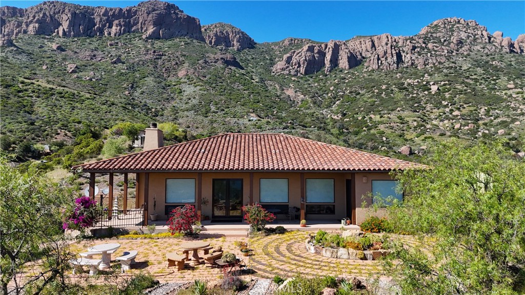 8400 Mipolomol Road Malibu, CA 90265 - Photo 49 of 58 a front view of a house with a yard outdoor seating and mountain view