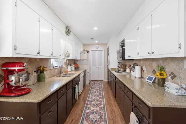 a kitchen with stainless steel appliances granite countertop a sink a stove and cabinets