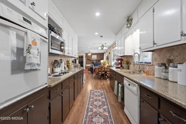 a living room with furniture a fireplace and a chandelier