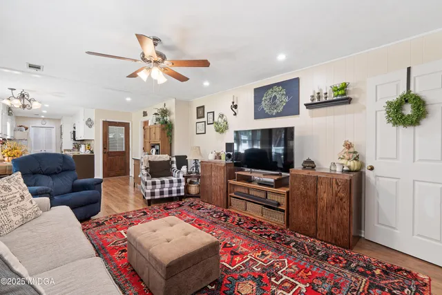 a view of a hallway with wooden floor and a chandelier