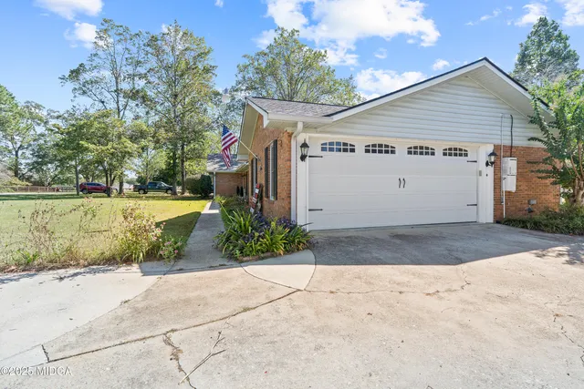a view of a house with backyard and sitting area