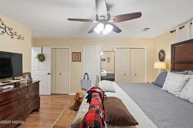 a backyard of a house with plants and large tree