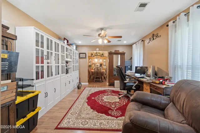 a view of a dining room with furniture a chandelier and wooden floor