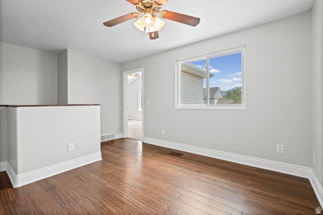 1346 Archmore Drive Springville, UT 84663 - Photo 13 of 32 Spacious room featuring wood-finish flooring, light grey walls, white baseboards, and a ceiling fan with integrated lighting