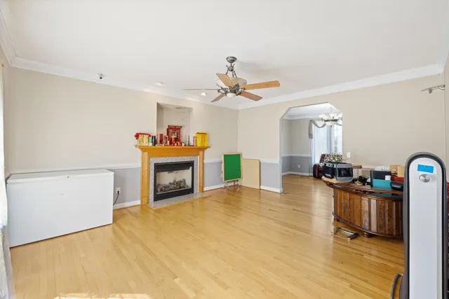 a view of a dining room and livingroom with furniture wooden floor a rug a chandelier