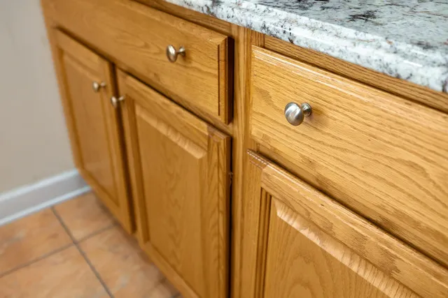 a kitchen with kitchen island granite countertop a sink cabinets and window