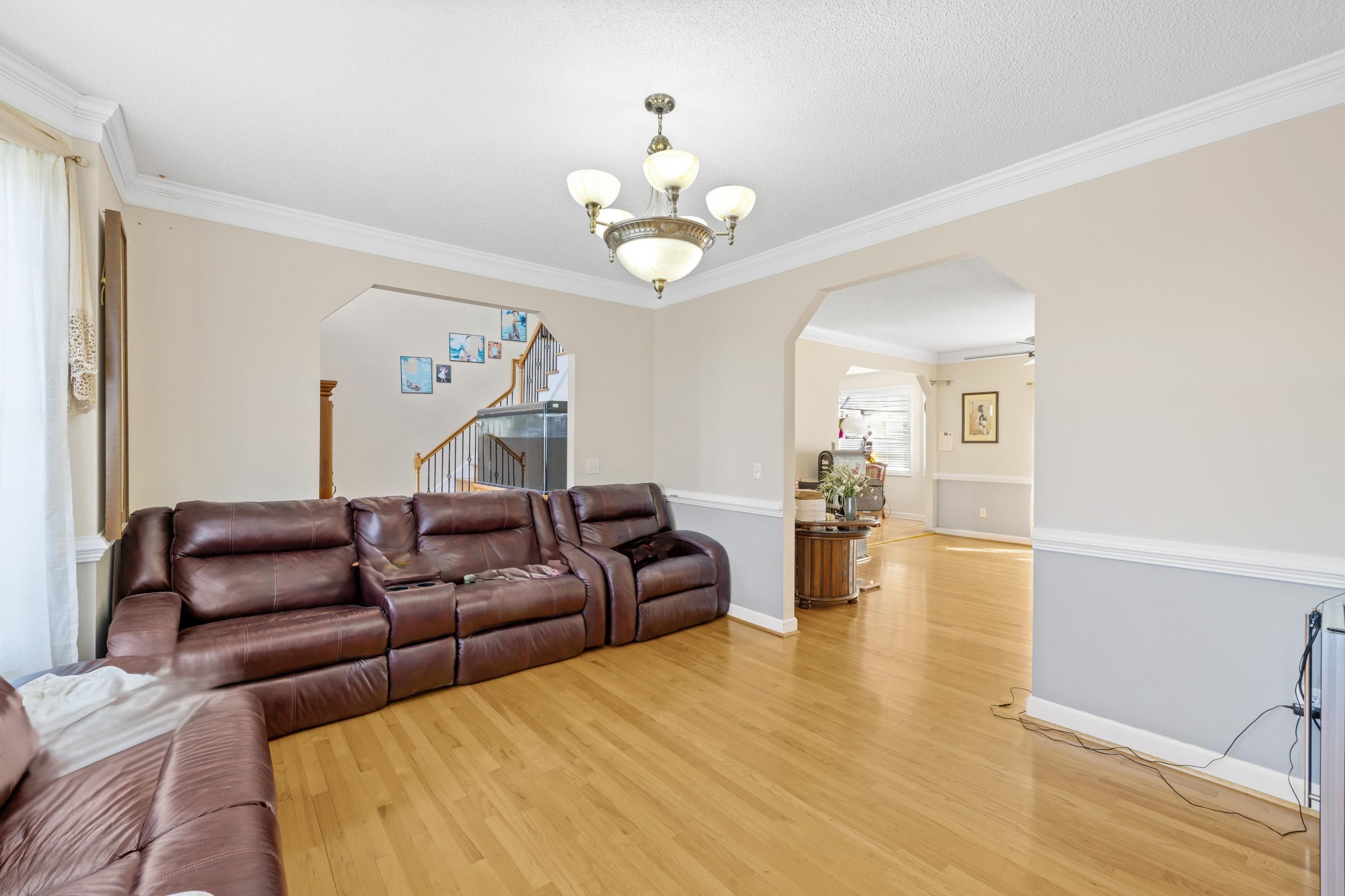 635 Long Meadow Road Fishersville, VA 22939 - Photo 7 of 63 a living room with couches chandelier and a dining table with wooden floor