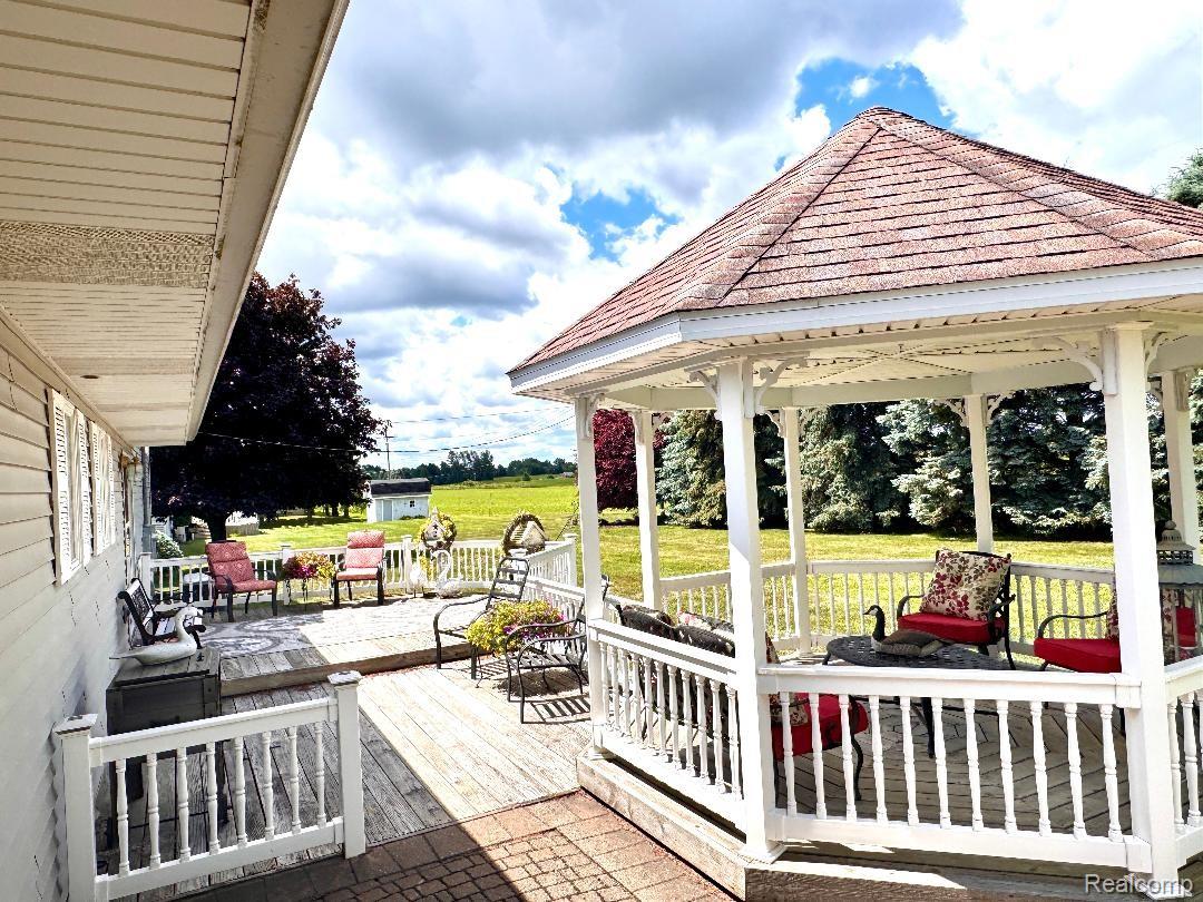 6686 South Schott Road Mayville, MI 48744 - Photo 23 of 25 Expansive outdoor deck area featuring a white gazebo with a shingle roof