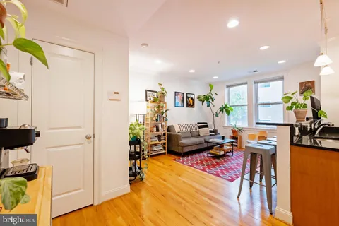 a living room with furniture and painting on the wall