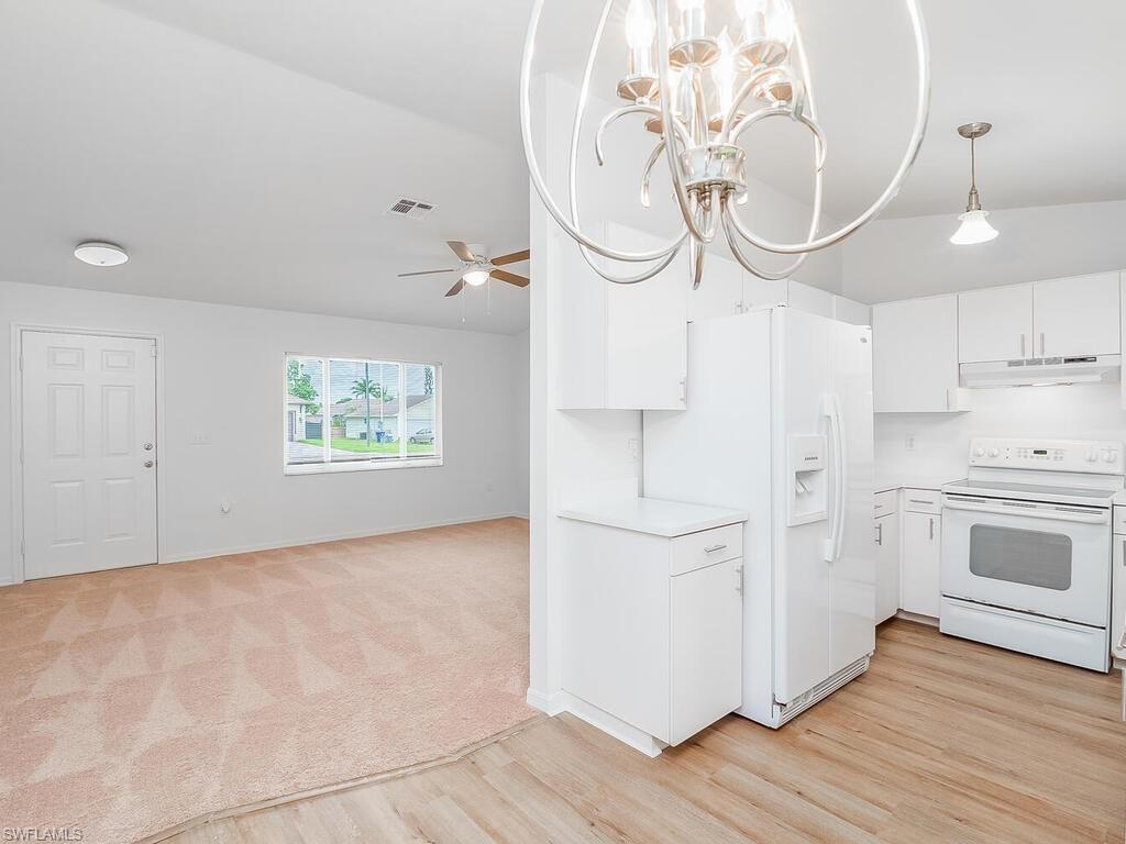 17432 Lee Road Fort Myers, FL 33967 - Photo 6 of 24 a view of a hallway with wooden floor and white cabinets