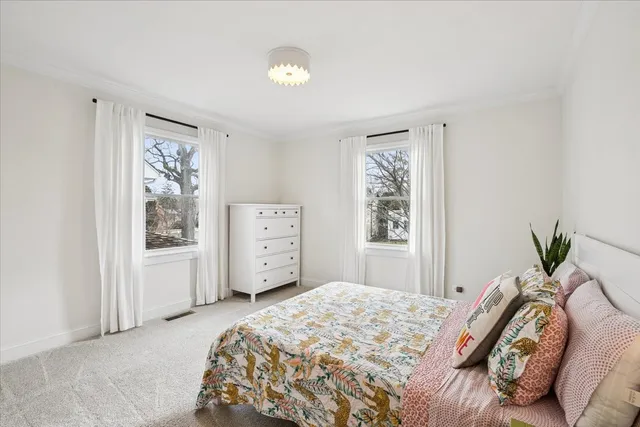 a bedroom with a bed dresser and a window