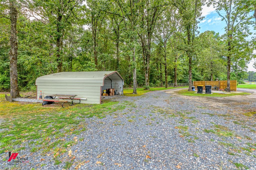 469 Foreman Road Doyline, LA 71023 - Photo 24 of 32 a backyard of a house with childrens swings and slides