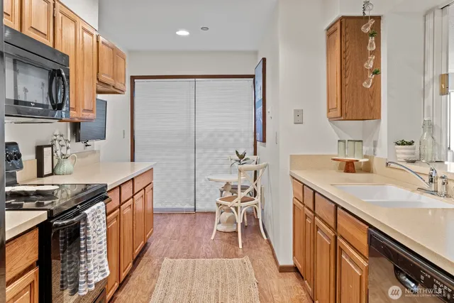 a kitchen with granite countertop a sink stove and cabinets