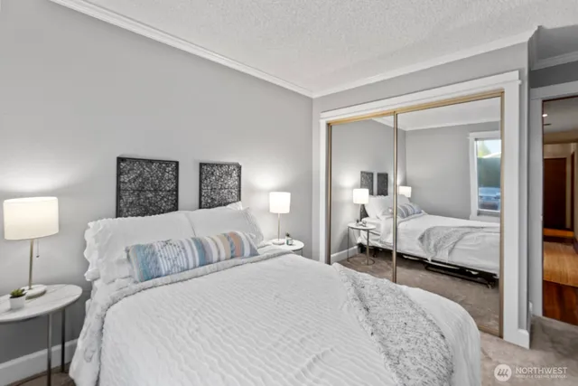 a bedroom with a bed and a large mirror