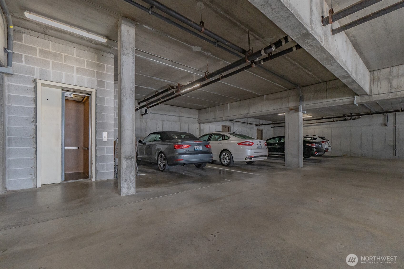 1902 Bridgeport Way West, Unit 106 University Place, WA 98466 - Photo 25 of 25 a view of parking garage with cars parked