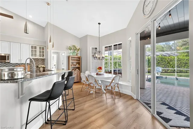 a living room with furniture large window and wooden floor