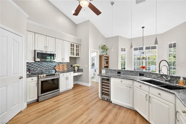 a kitchen with granite countertop a sink cabinets stainless steel appliances and a counter space