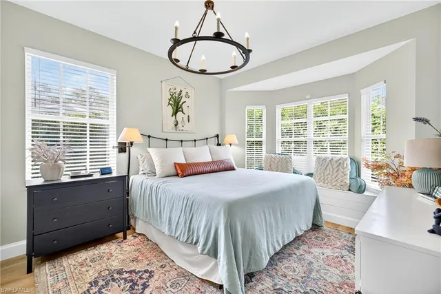 a view of pool with lawn chairs and floor to ceiling window