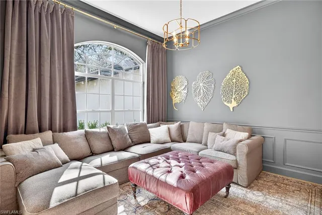 a living room with furniture a chandelier and a window