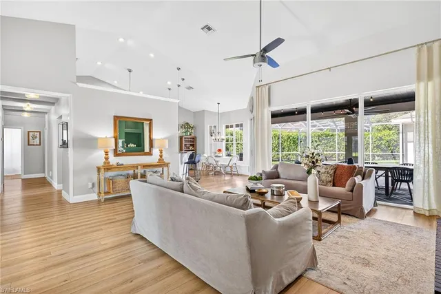 a living room with furniture large window and wooden floor