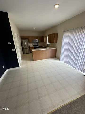 a kitchen with stainless steel appliances granite countertop a refrigerator a stove a sink a microwave and wooden cabinets