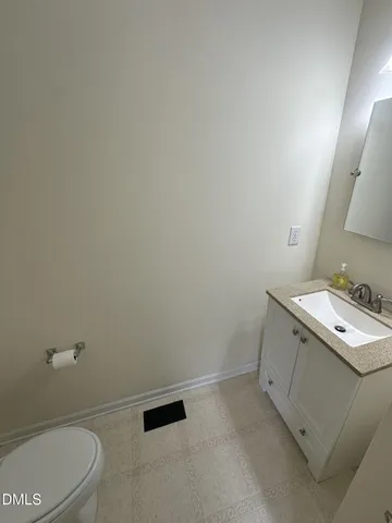 an empty room with chandelier fan and windows