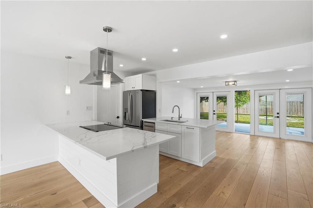 a kitchen with stainless steel appliances granite countertop a sink a stove and a wooden floors