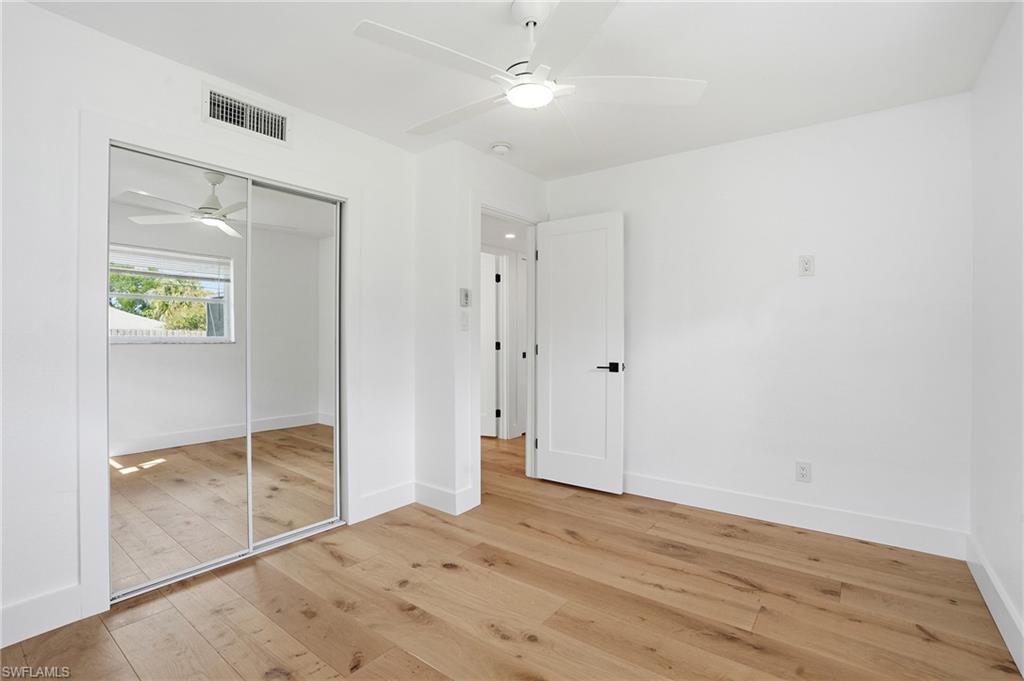 1205 Hilltop Drive Naples, FL 34103 - Photo 12 of 15 an empty room with wooden floor and mirror