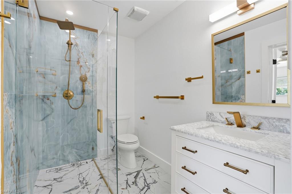 1205 Hilltop Drive Naples, FL 34103 - Photo 2 of 15 a bathroom with a granite countertop sink a toilet and shower