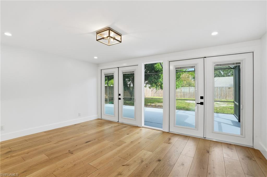 1205 Hilltop Drive Naples, FL 34103 - Photo 5 of 15 an empty room with wooden floor and windows
