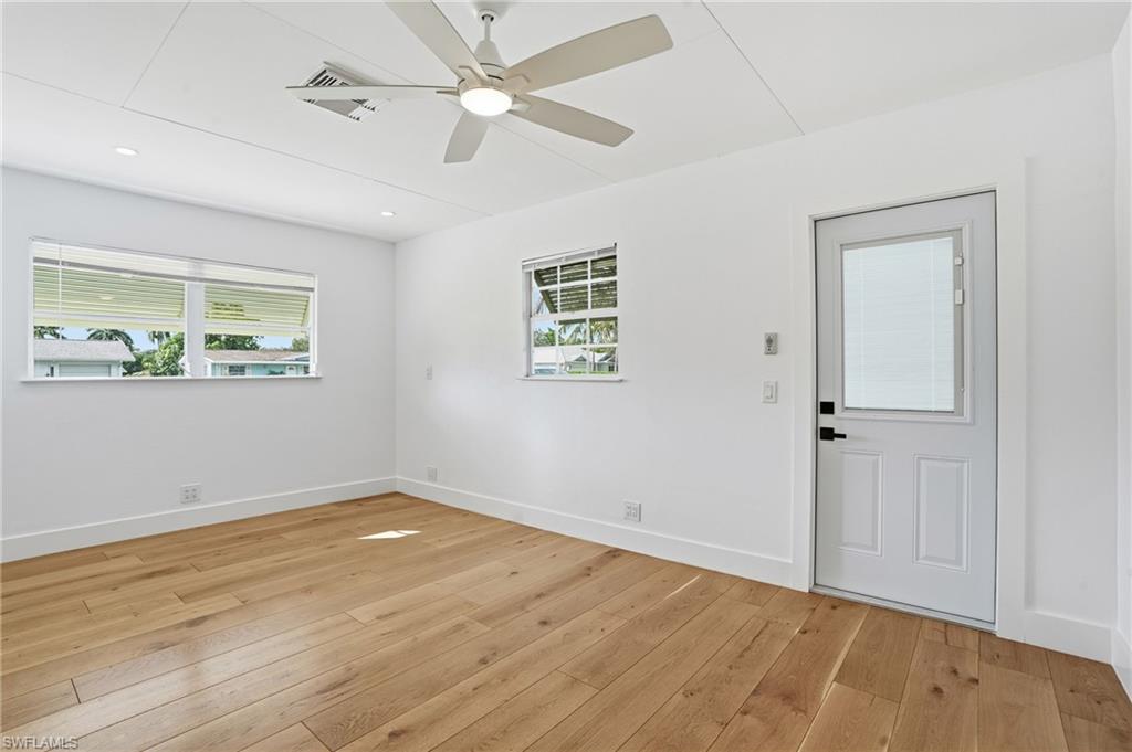 1205 Hilltop Drive Naples, FL 34103 - Photo 8 of 15 wooden floor in an empty room with a window