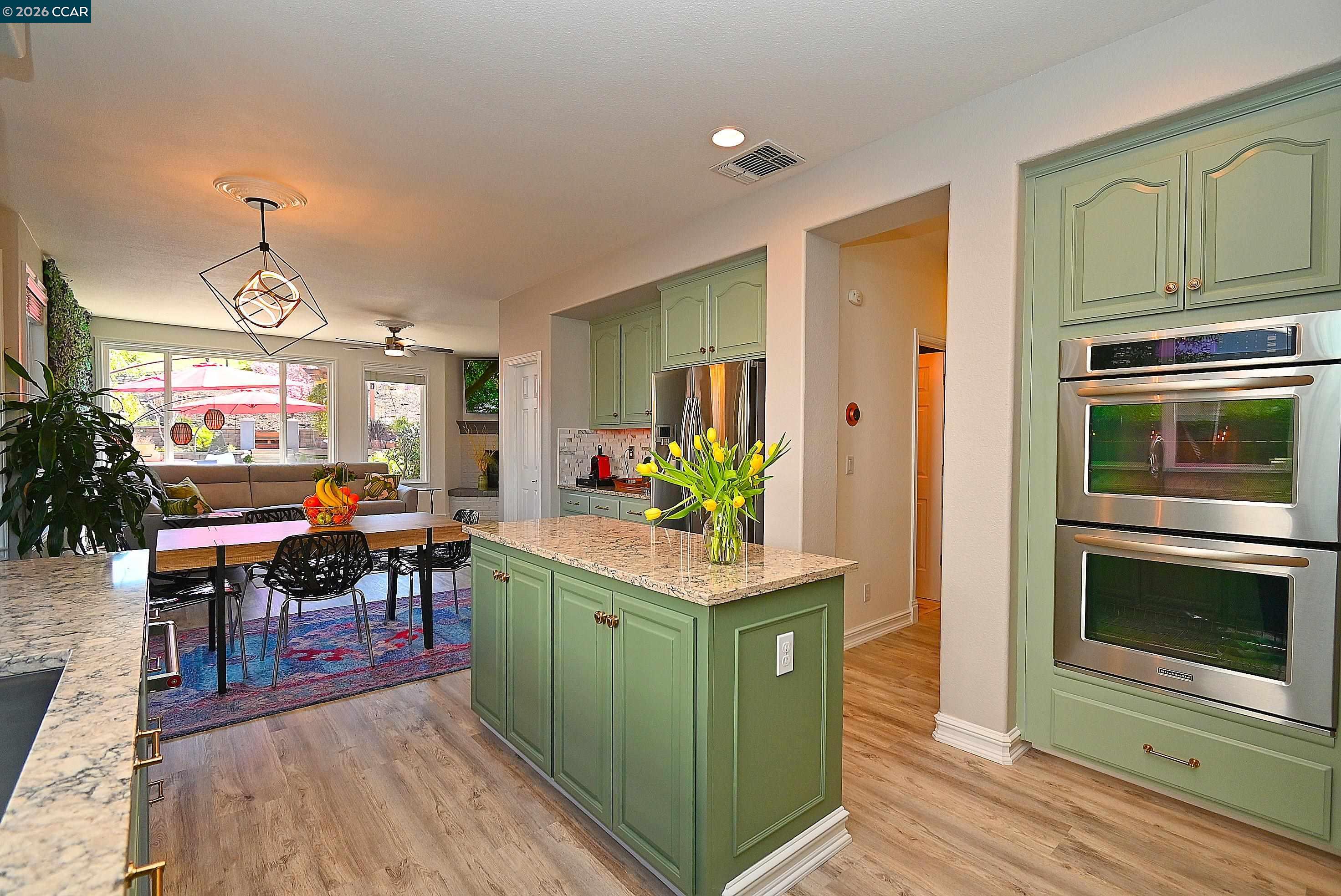 829 Deer Spring Circle Concord, CA 94521 - Photo 13 of 50 a kitchen with stainless steel appliances kitchen island granite countertop a table and chairs in it