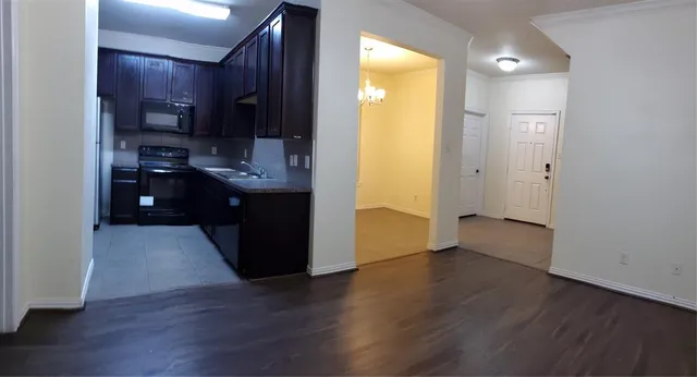 a kitchen with wooden floors and cabinets