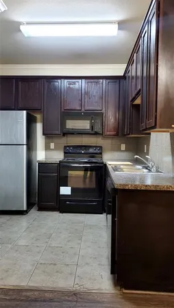 a kitchen with a sink a stove a refrigerator and cabinets