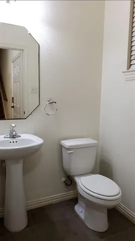 a bathroom with a toilet a sink and mirror