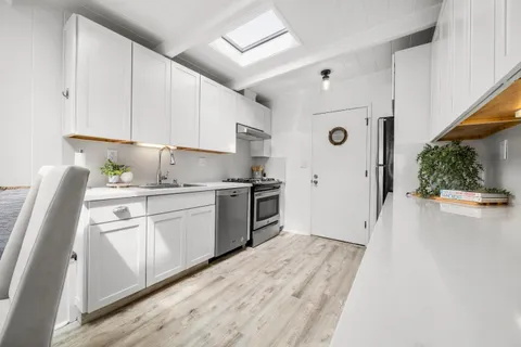 a kitchen with stainless steel appliances a refrigerator sink and cabinets