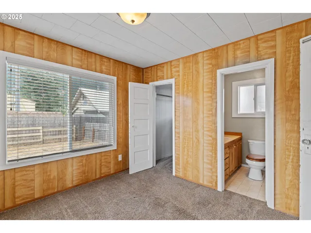 a utility room with water heater and a refrigerator
