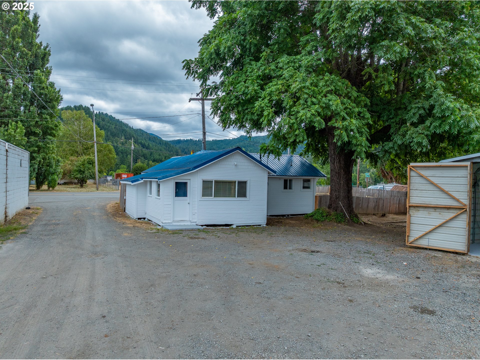 141 Poplar Street Powers, OR 97466 - Photo 24 of 37 a view of a house with a yard and large trees