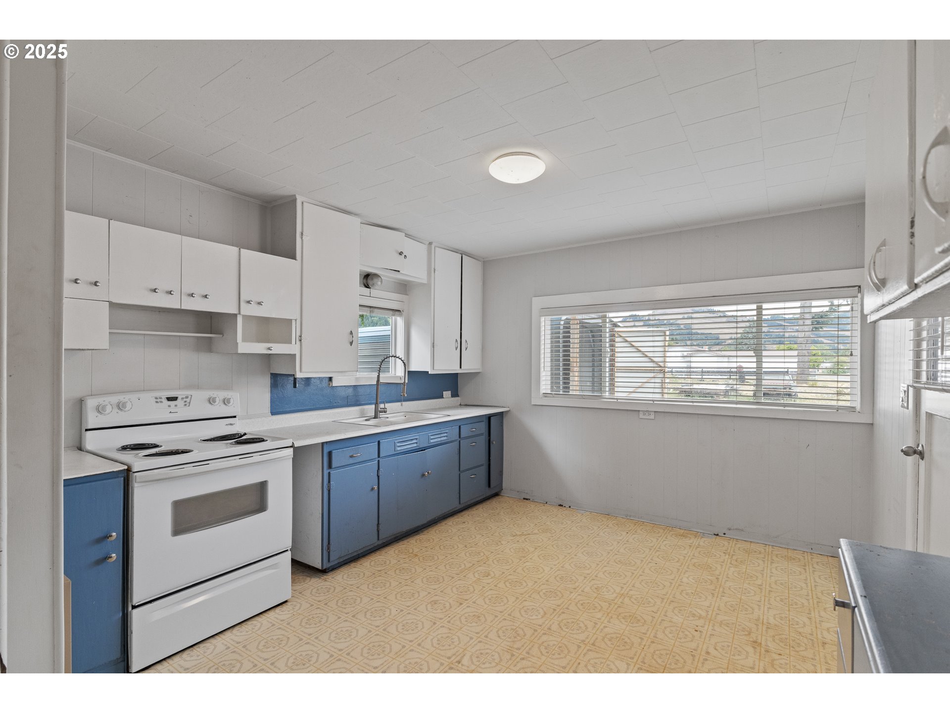 141 Poplar Street Powers, OR 97466 - Photo 6 of 37 a kitchen with stainless steel appliances granite countertop a stove a sink and white cabinets