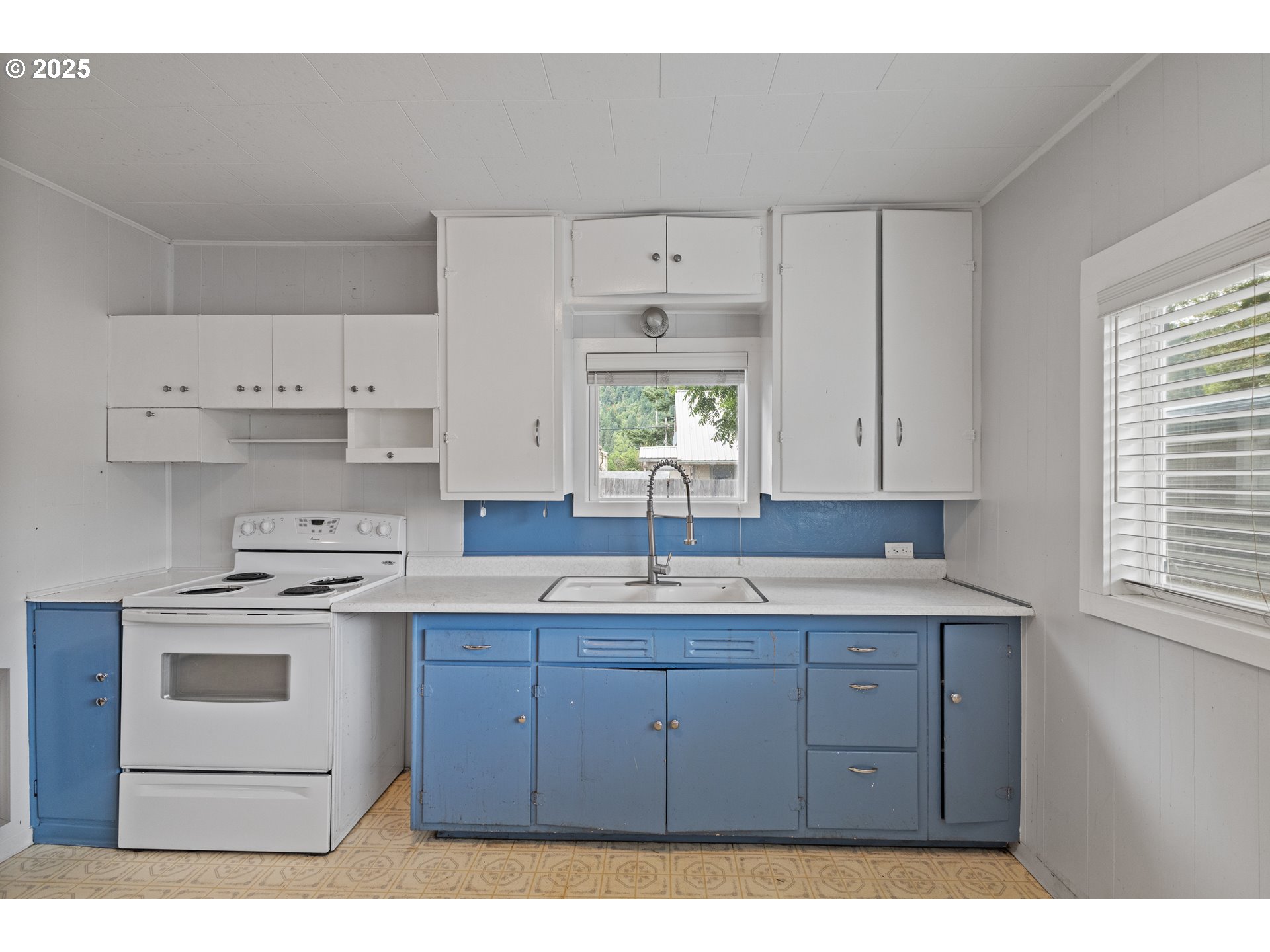 141 Poplar Street Powers, OR 97466 - Photo 9 of 37 a kitchen with a sink window and cabinets