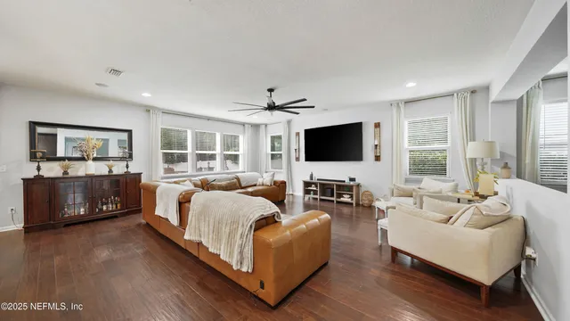 a living room with a bed and a flat screen tv