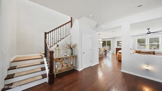 a kitchen with stainless steel appliances granite countertop a stove refrigerator a dining table and chairs with wooden floor