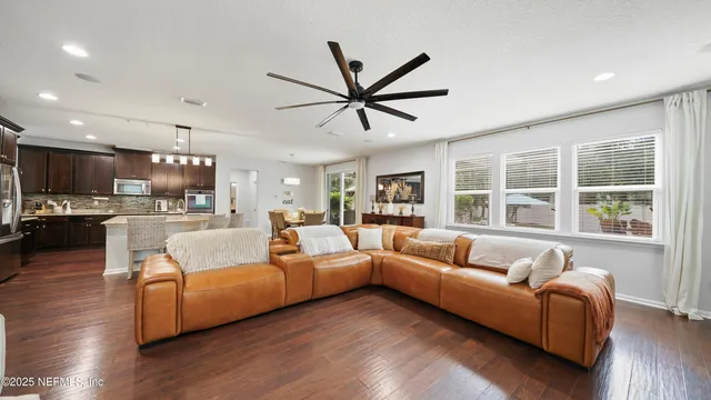 a kitchen with stainless steel appliances kitchen island granite countertop a refrigerator a stove top oven a sink dishwasher with a dining table and chairs