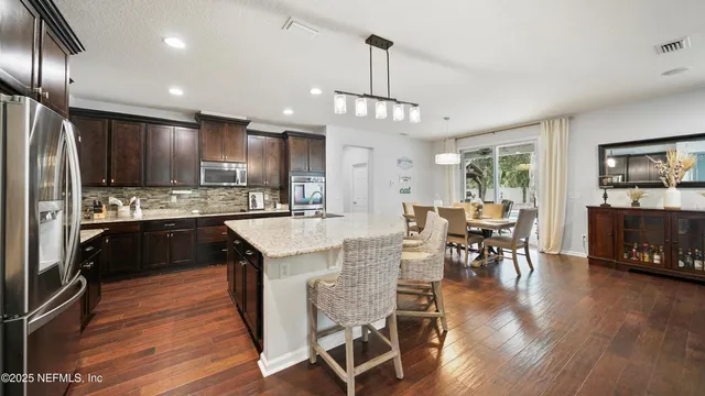 a kitchen with stainless steel appliances granite countertop a sink stove and wooden floor