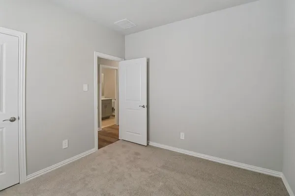 an empty room with closet and a bathroom