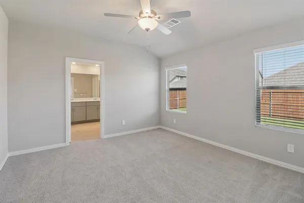 an empty room with windows and fan