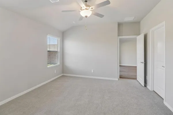 an empty room with windows and fan
