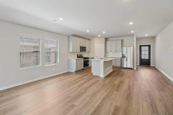 a view of kitchen with wooden floor and electronic appliances