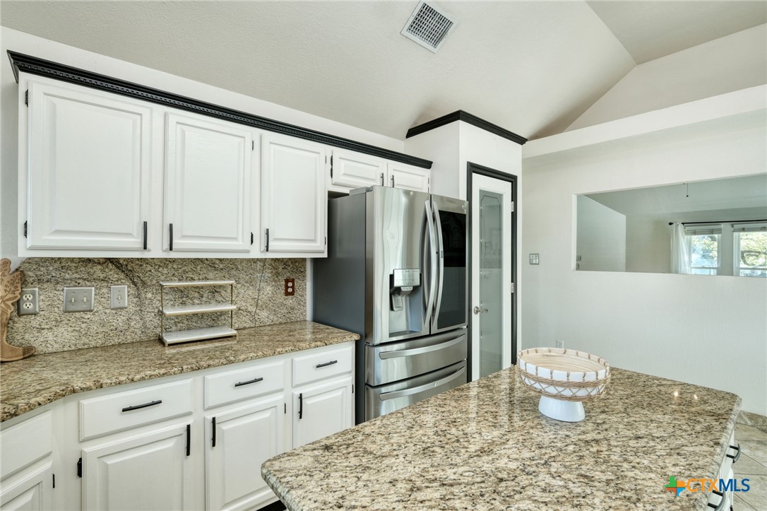 3403 Northwest Boulevard Georgetown, TX 78628 - Photo 10 of 28 a kitchen with a refrigerator and cabinets